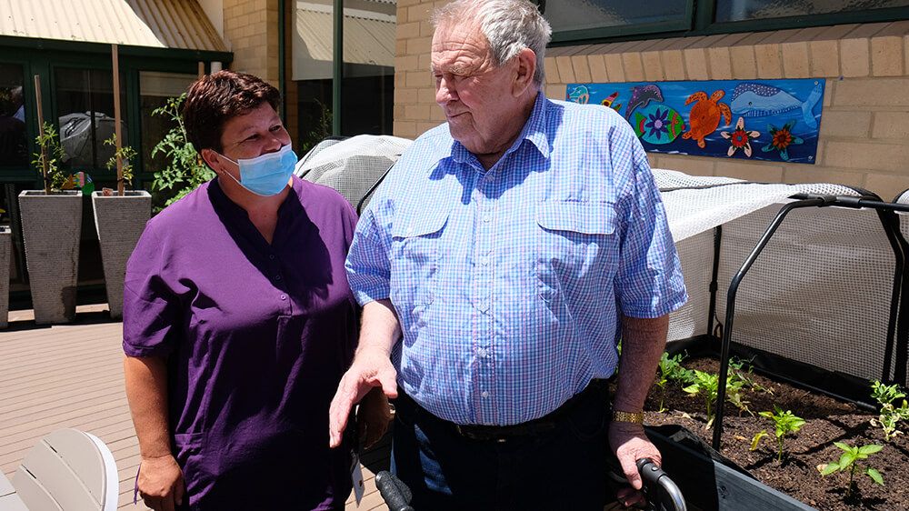 Laura Farley, chatting here with Waratah Lodge resident Alan Donchi, has been playing an important role keeping our aged care residents connected with their families during COVID.